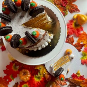 pumpkin oreo cake with oreo creamcheese frosting set atop orange, yellow, and brown fall decor